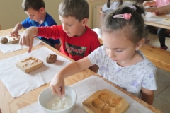 dzieci sypią mąkę do foremek