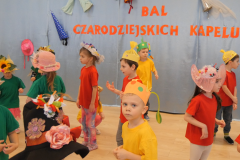 dzieci tańczą w kolorowych kapeluszach