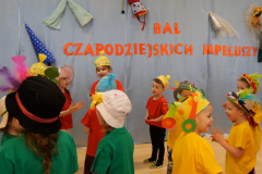 dzieci tańczą w kolorowych kapeluszach