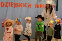 dzieci tańczą w kolorowych kapeluszach