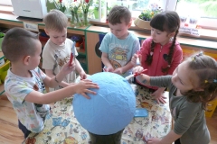 dzieci malują kulę ziemską