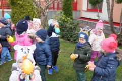 dzieci wieszają pisanki na drzewach
