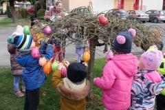 dzieci wieszają pisanki na drzewach